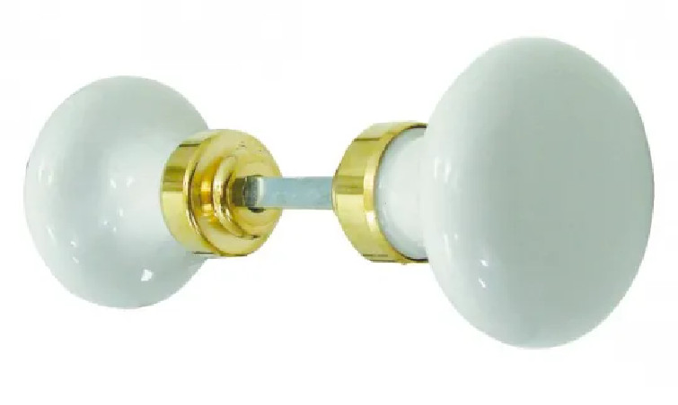 Round double knob in white porcelain and polished brass.