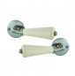 Set of double-barrel lever handles in unbleached porcelain on satin nickel rosette.